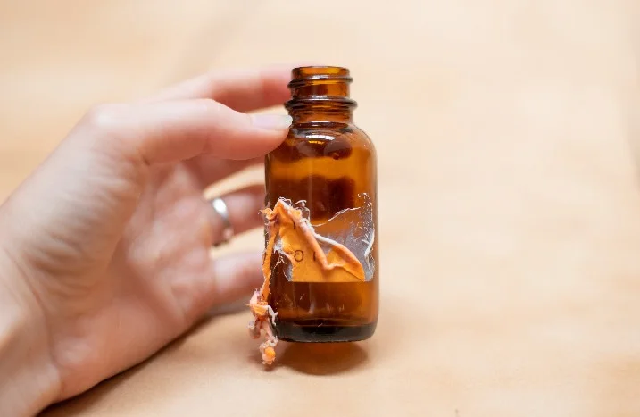 Hand hält Braunglasflasche mit Etikett